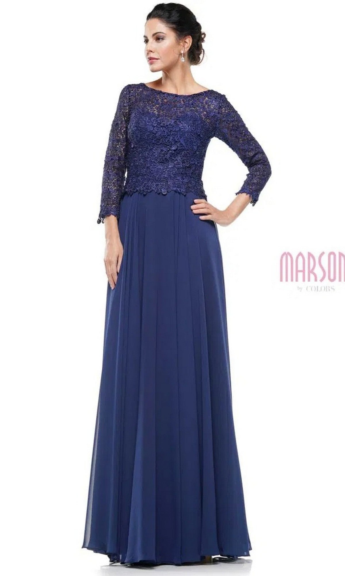 A woman stands against a white background wearing the Marsoni M223, a navy blue long formal dress featuring a lace bodice, three-quarter sleeves, and a flowing chiffon skirt.
